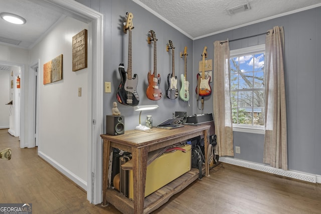 interior space featuring hardwood / wood-style flooring, ornamental molding, and a textured ceiling