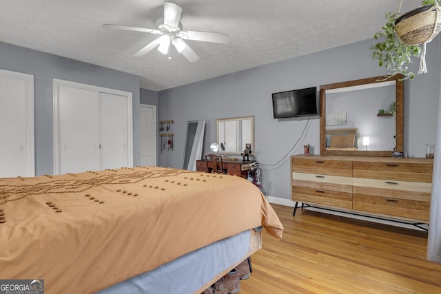 bedroom with hardwood / wood-style flooring, ceiling fan, and a textured ceiling