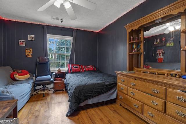 bedroom featuring a textured ceiling, ceiling fan, and light hardwood / wood-style flooring