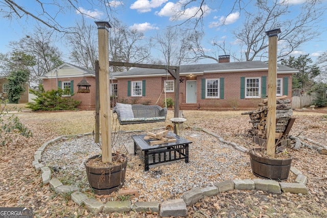 back of house featuring an outdoor living space with a fire pit