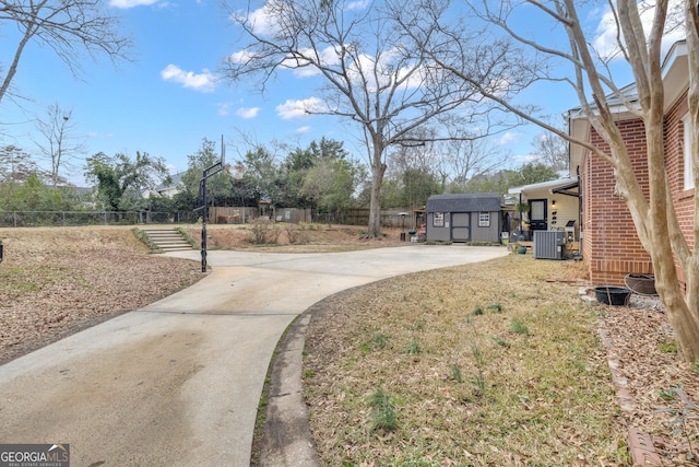 view of yard featuring central AC and a shed