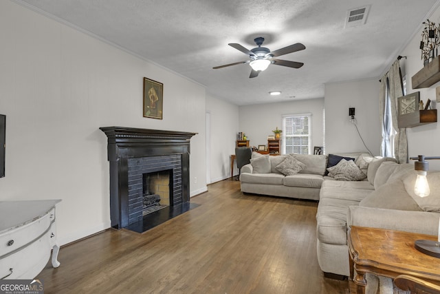 living room featuring ceiling fan, dark hardwood / wood-style flooring, and a textured ceiling