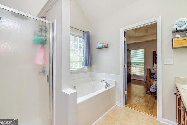 bathroom with vanity, vaulted ceiling, tile patterned floors, and shower with separate bathtub