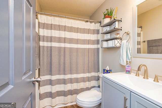 bathroom featuring vanity, toilet, and a textured ceiling