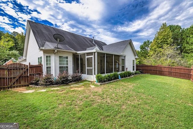 rear view of property featuring a sunroom and a lawn