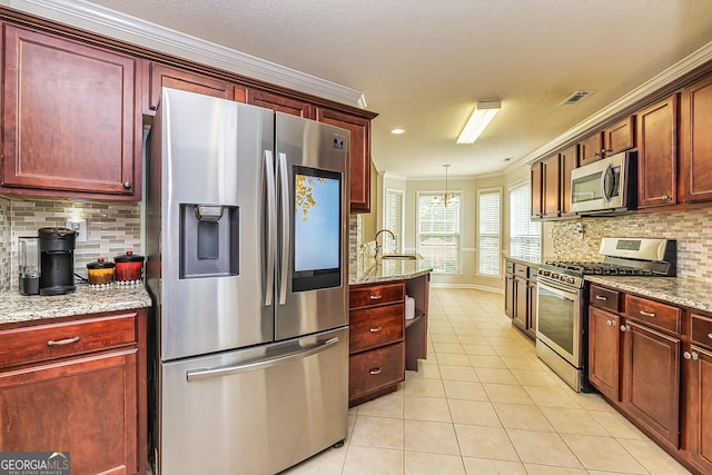 kitchen featuring hanging light fixtures, light tile patterned floors, stainless steel appliances, and light stone countertops