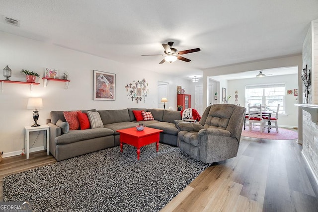 living room featuring wood-type flooring and ceiling fan