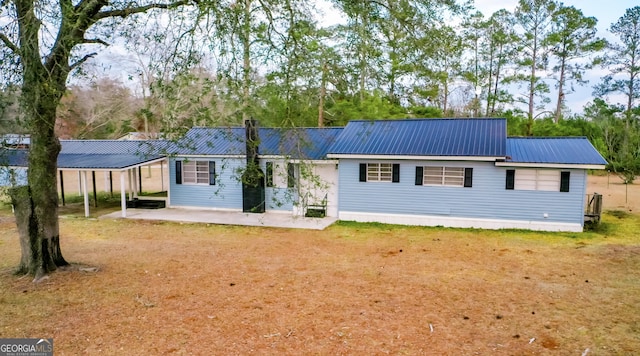 back of property with a patio area and a lawn