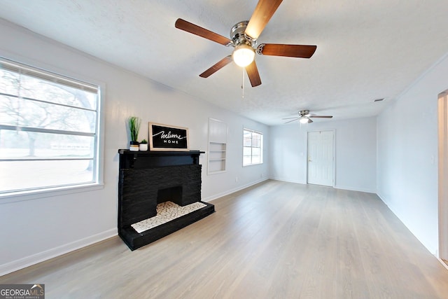 living room with light hardwood / wood-style flooring, built in features, and a textured ceiling