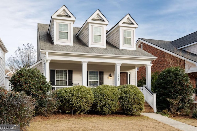 cape cod-style house featuring covered porch