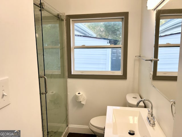 bathroom featuring sink, an enclosed shower, and toilet