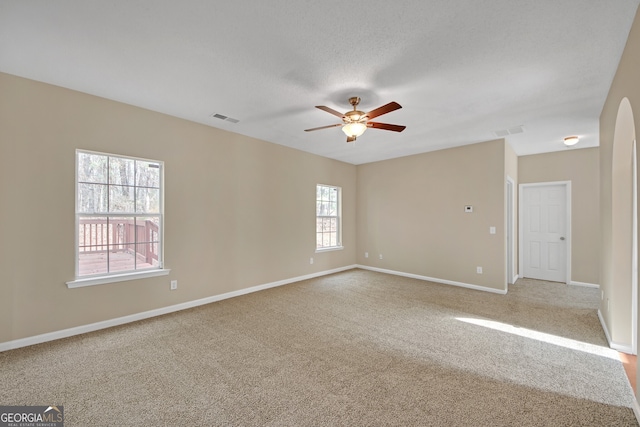 unfurnished room with ceiling fan, light colored carpet, and a textured ceiling