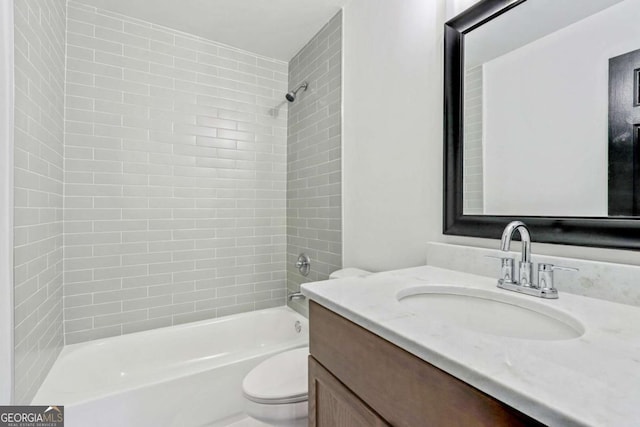 full bathroom with tiled shower / bath, vanity, and toilet