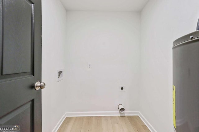 clothes washing area featuring water heater, hookup for a washing machine, light hardwood / wood-style flooring, and electric dryer hookup