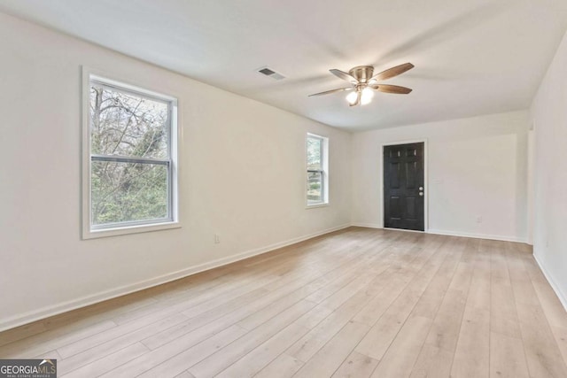 spare room with ceiling fan, a healthy amount of sunlight, and light wood-type flooring