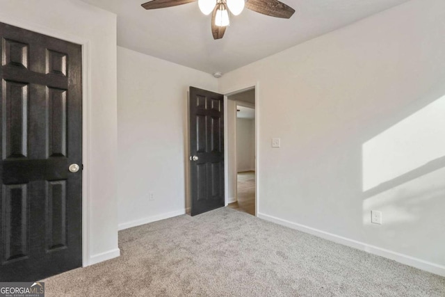 unfurnished bedroom with ceiling fan and light carpet