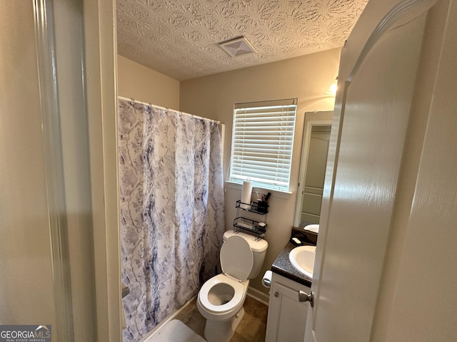 bathroom with walk in shower, vanity, toilet, and a textured ceiling