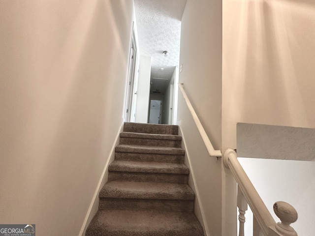 stairway with a textured ceiling