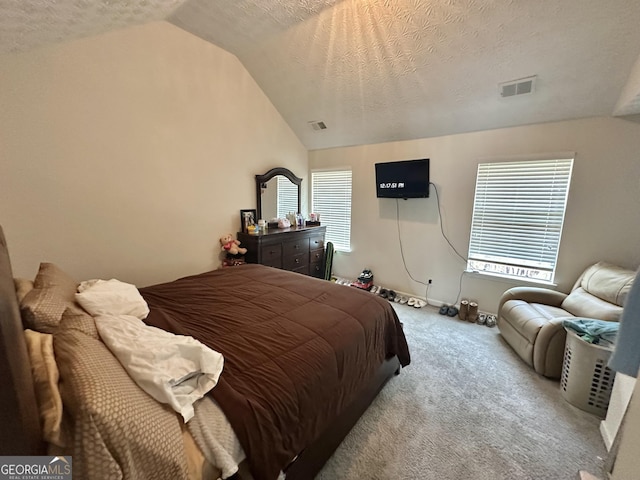 bedroom with lofted ceiling, light carpet, and a textured ceiling