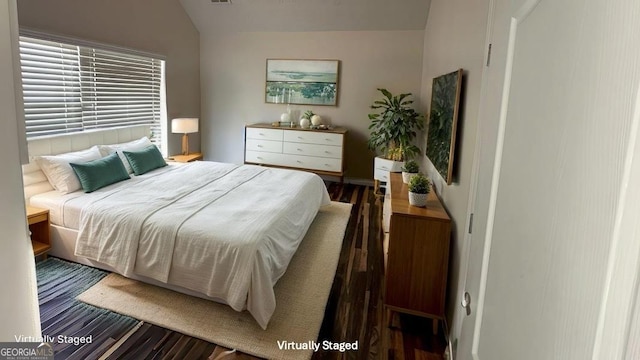 bedroom with lofted ceiling and dark wood-type flooring