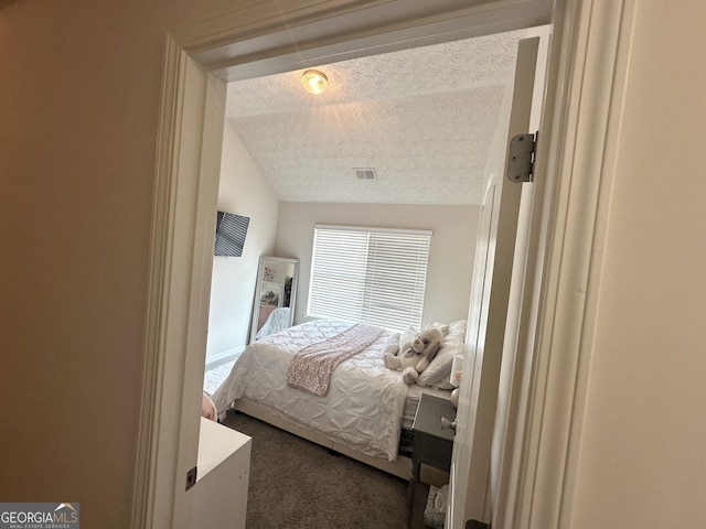 bedroom with carpet, lofted ceiling, and a textured ceiling