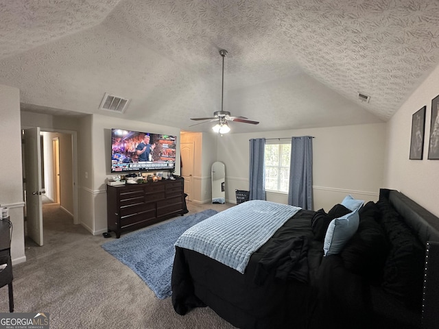 bedroom featuring ceiling fan, light colored carpet, vaulted ceiling, and a textured ceiling