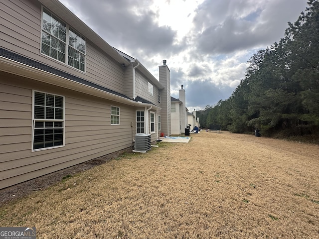 view of property exterior featuring cooling unit and a yard