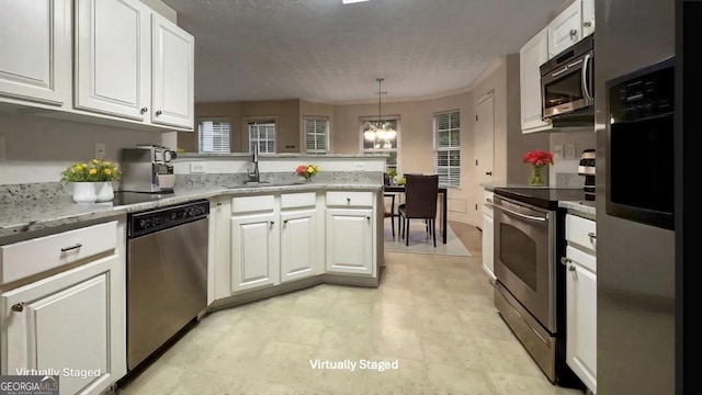 kitchen featuring pendant lighting, white cabinets, kitchen peninsula, stainless steel appliances, and light stone countertops