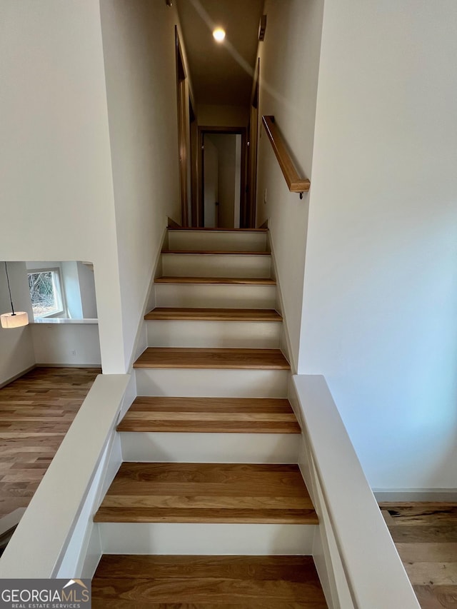 stairs featuring hardwood / wood-style flooring