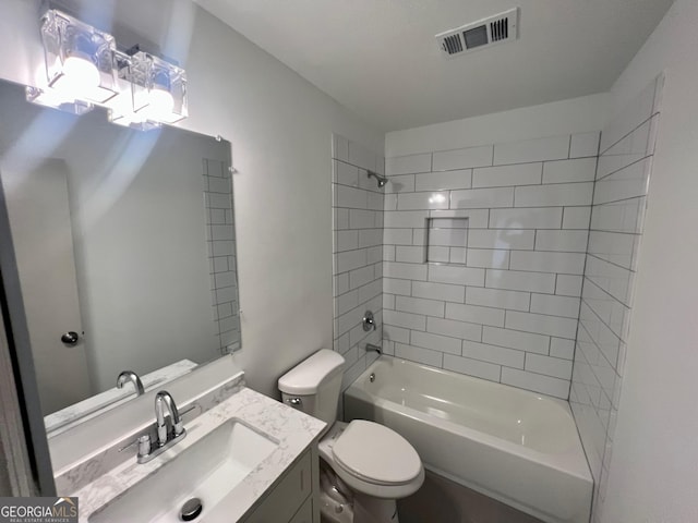 full bathroom with tiled shower / bath, vanity, and toilet