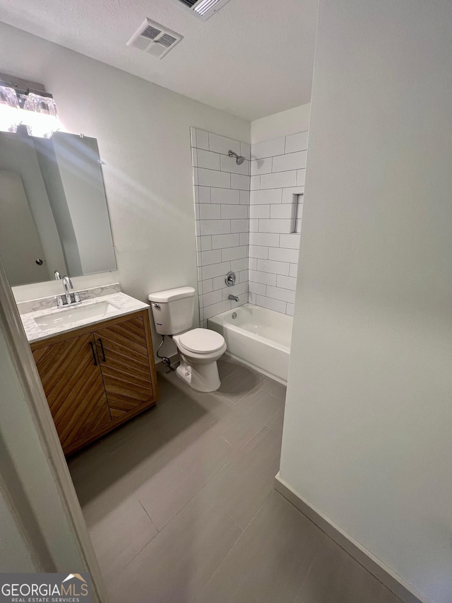 full bathroom featuring tiled shower / bath combo, vanity, a textured ceiling, and toilet