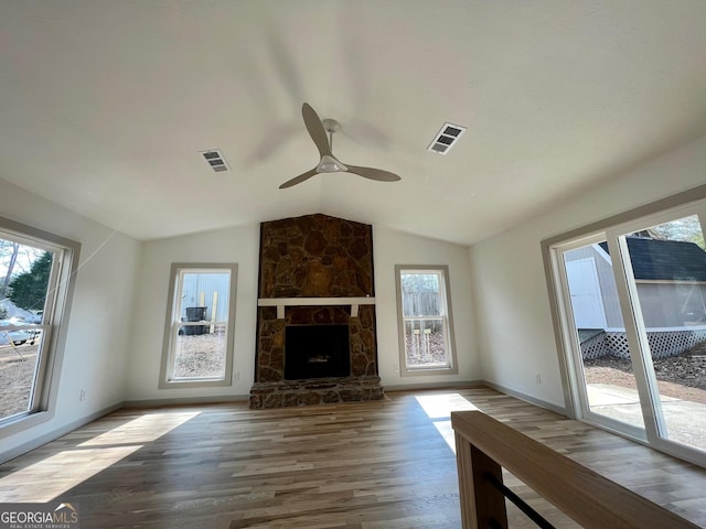 unfurnished living room featuring lofted ceiling, hardwood / wood-style floors, a fireplace, and ceiling fan