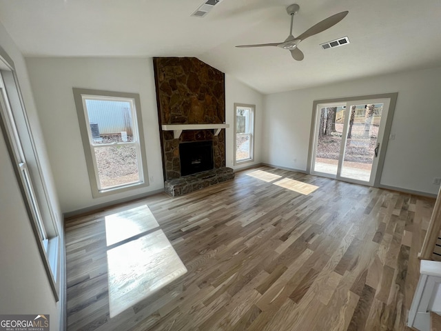 unfurnished living room featuring a fireplace, vaulted ceiling, ceiling fan, and light wood-type flooring