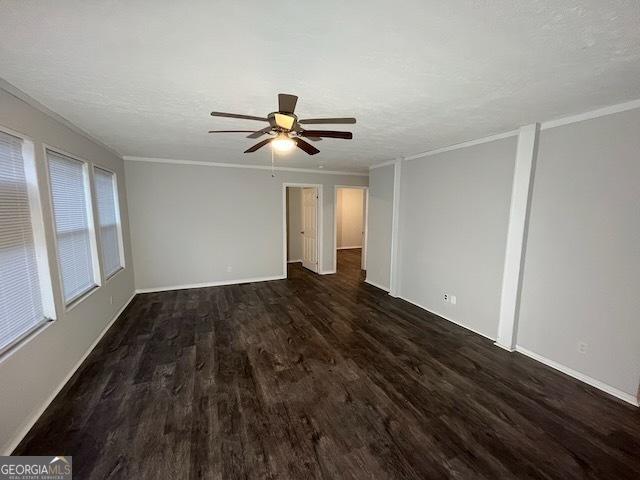 unfurnished room with ceiling fan, crown molding, dark wood-type flooring, and a textured ceiling