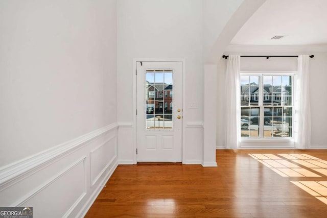 entryway with hardwood / wood-style flooring and crown molding