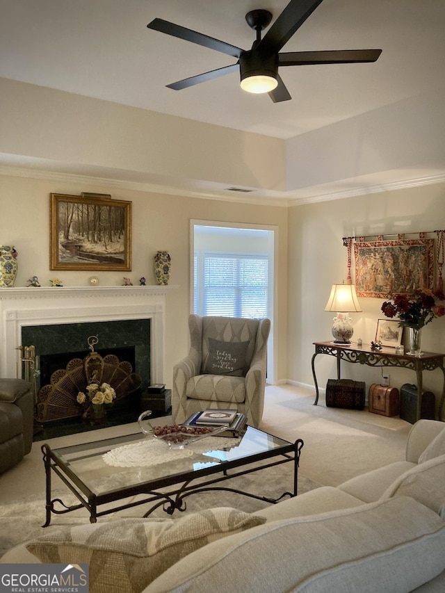 carpeted living room featuring ornamental molding and ceiling fan