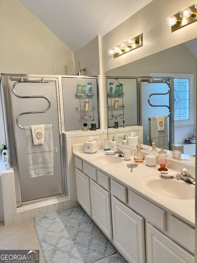 bathroom featuring an enclosed shower, vanity, vaulted ceiling, and tile patterned floors