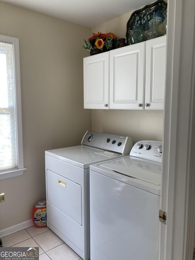 laundry area featuring cabinets, independent washer and dryer, and light tile patterned flooring