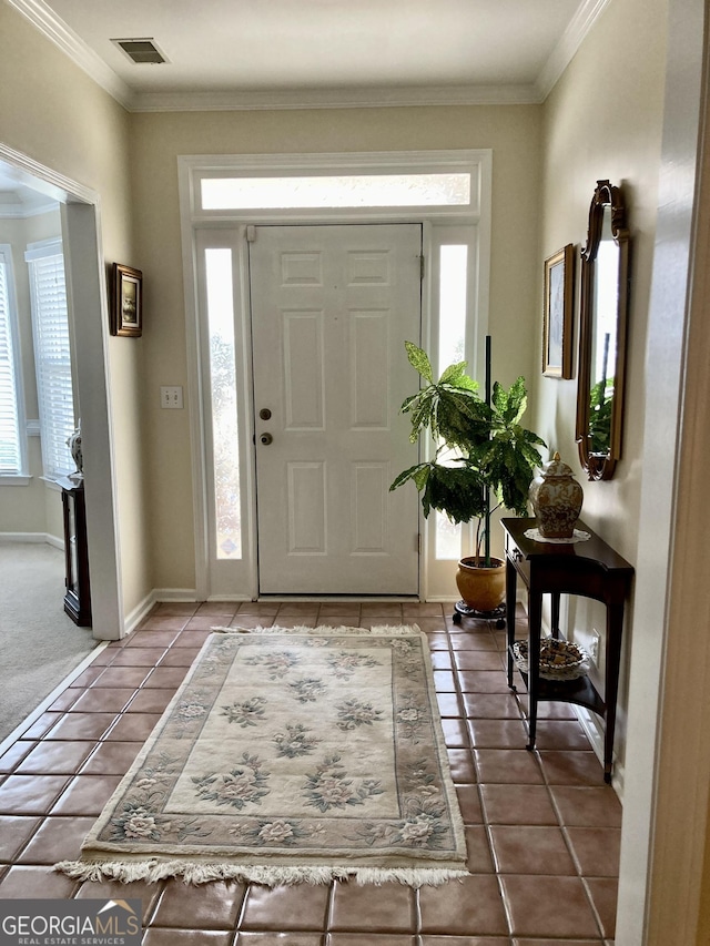 entryway with tile patterned flooring and crown molding