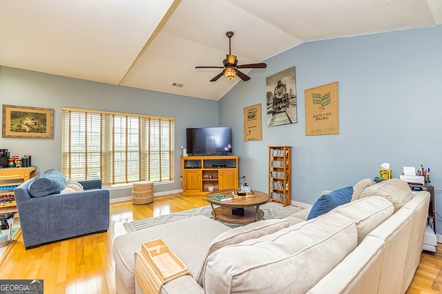 living room featuring ceiling fan, vaulted ceiling, and light wood-type flooring