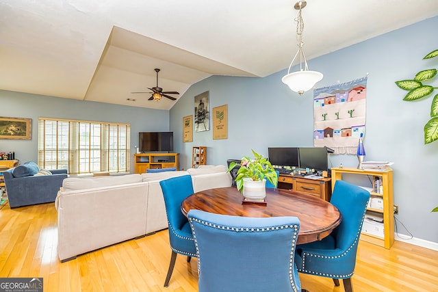 dining space with ceiling fan, lofted ceiling, and light hardwood / wood-style floors