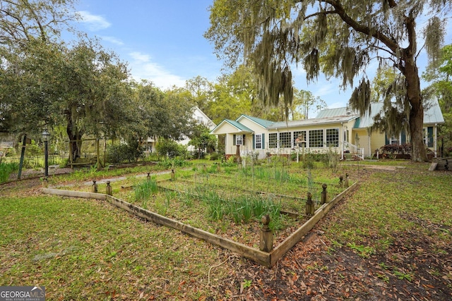 64 Lake No No Rd, Midway, GA 31320 - view of front of house with a vegetable garden and a metal roof