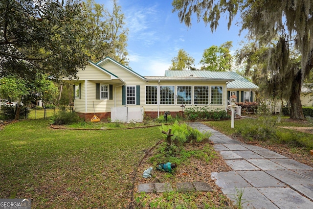 64 Lake No No Rd, Midway, GA 31320 - view of front of house featuring a metal roof and a sunroom