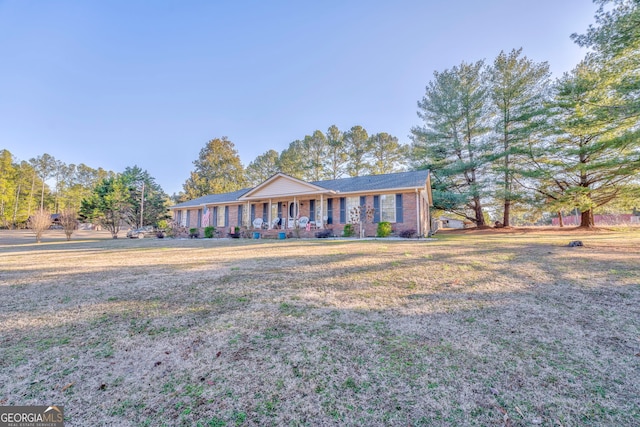 ranch-style home with a front yard and covered porch