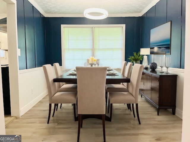 dining space with crown molding, light hardwood / wood-style flooring, and a textured ceiling