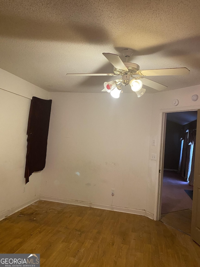 unfurnished room with wood-type flooring, ceiling fan, and a textured ceiling