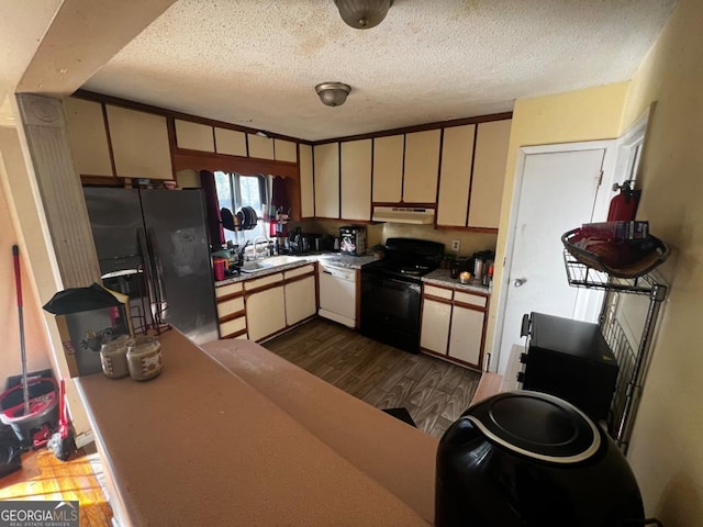 kitchen with dark hardwood / wood-style flooring, sink, black appliances, and cream cabinetry