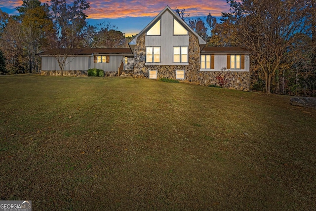 back house at dusk with a lawn