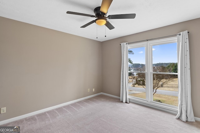 carpeted empty room featuring ceiling fan