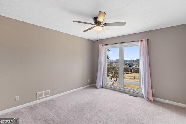 carpeted spare room featuring a textured ceiling and ceiling fan